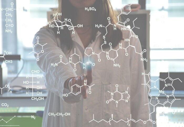 Woman in a lab coat touching a virtual chemical symbol diagram
