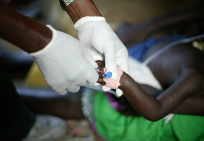 Child receives care in hospital by medical practitioner wearing gloves