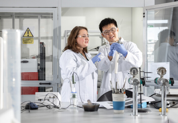 Two researchers in the laboratory wear white lab coats