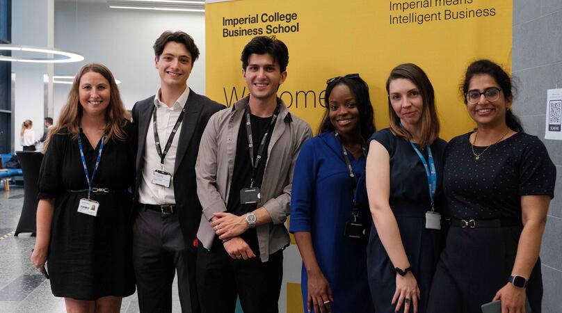 Group of MSc Finance & Accounting students posing together in front of an Imperial banner